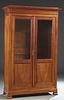 French Louis Philippe Carved Cherry Bookcase, 19th c., the stepped edge top over double doors with glazed upper panels over wood lower panels, on a pl