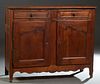 French Louis XV Style Carved Cherry and Oak Sideboard, 19th c., the canted corner top over two frieze drawers, above double cupboard doors with iron f
