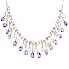 An amethyst and topaz fringe necklace. Designed as a series of graduated oval-shape amethyst and col