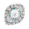 A diamond and emerald dress ring. Of geometric design, the circular-cut diamond, within a calibre-cu
