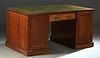 English Carved Mahogany Partner's Desk, early 20th c., the gilt tooled green leather top on double pedestals, joined by a center drawer, each with fou