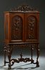 American Carved Walnut Dining Room Cabinet, 20th c., the pierced floral basket crest over a stepped crown above double arched doors with high relief w