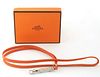 Hermes Ultrasonic Silver Whistle Necklace, with an orange calf leather rope, with Hermes booklet and presentation box, L.- 19 1/2 in.
