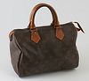 Louis Vuitton Brown Monogram Coated Canvas 25 Speedy Handbag, with golden brass hardware, opening to a light brown canvas lined interior with a small 