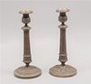 Par de candeleros. Inglaterra, inicios siglo XX. Diseño de columna. Elaborados en metal dorado patinado. Piezas: 2