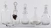 Five colorless glass decanters and wine taster