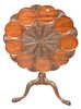 George II Mahogany Tip Tea Table, having carved shaped top on turned shaft, set on tripod base with dolphin ends, 18th century, height 28 inches, diam