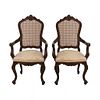 Par de sillones. SXX. Talla en madera. Con respaldos cerrados de bejuco y asientos en tapicería color beige.