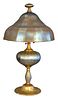 Douglas Nash Table Lamp having gold iridescent glass, ribbed bell form shade over standard, with glass supports, marked 'Douglas Nash Corp. 704' on bo