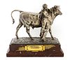 A silvered bronze agricultural trophy in the form of a bull and handler,