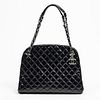 Chanel Mademoiselle Shoulder Bag, in black quilted aged patent calf leather with silver hardware, opening to a black canvas lined interior with a CC l