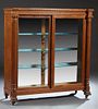 American Carved Tiger Oak Bookcase, c. 1900, the stepped breakfront top over setback double glazed sliding doors, flanked by engaged reeded Ionic colu