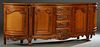 French Louis XV Style Carved Cherry Sideboard, 20th c., the parquetry inlaid serpentine top over a central bank of four drawers, flanked by concave fi