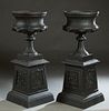 Pair of Cast Aluminum Urns on Stands, 20th/21st c., the everted rim over baluster floral relief sides, on a tapered socle support, to an integral squa