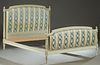 French Louis XVI Style Carved Polychromed Beech Double Bed, 20th c., the stepped arched upholstered headboard with artichoke finials, atop reeded tape