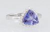 Lady's 18K White Gold Dinner Ring, with a 2.1 ct. trillion cut tanzanite atop a conforming border of small round diamonds, total diamond wt.- .33 cts,