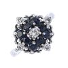 An 18ct gold sapphire and diamond cluster ring. The brilliant-cut diamond, within a circular-shape s