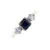 A mid 20th century 18ct gold sapphire and diamond three-stone ring. The square-shape sapphire, to th