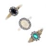 A selection of three 9ct gold diamond and gem-set cluster rings. Each set with an oval-shape emerald