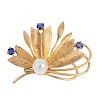 A cultured pearl and sapphire floral brooch. Designed as a stylised floral spray, with cultured pear