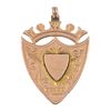 A late Victorian 9ct gold medallion. Of shield-shape outline, with scrolling accents and stylised cr