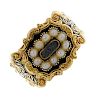 A George IV 18ct gold memorial ring. The central domed glass panel surrounded by seed pearls to the