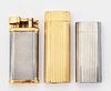 A GROUP OF THREE VINTAGE LIGHTERS, comprising two by Cartie