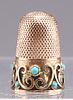 AN EDWARDIAN GOLD AND TURQUOISE THIMBLE, unmarked, with app