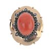 An early 20th century gold coral and diamond brooch. The oval coral cabochon, within a petal and scr