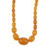 A natural amber necklace. Designed as thirty-five graduated oval-shape beads measuring 8 to 2.2cms,