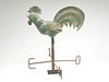 Full body copper weathervane of a crowing rooster.