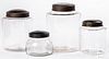 Four tin and colorless glass store counter jars