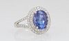 Lady's Platinum Dinner Ring, with an oval 2.76 carat tanzanite atop a double concentric graduated border of round diamonds, the split shoulders of the