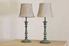 A pair of verdigris candlestick lamps,