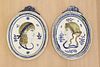 A pair of oval moulded pottery plaques,