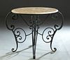 French Style Iron and Marble Top Garden Table, 20th c., the stepped highly figured circular marble top on four triple scrolled iron legs, joined by sc