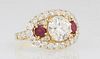 Lady's 18K Yellow Gold Dinner Ring, with a central 2.9 carat round diamond, flanked by two round rubies, within an oval border of round white diamonds