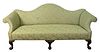 Chippendale Style Upholstered Sofa, having rolled arms and carved legs ending in ball and claw feet, height 38 inches, length 84 inches.