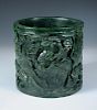 A spinach green jade brush pot, the exterior of the cylindrical shape carved in deep relief with two
