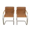 Par de sillones Cantilever. SXX. Diseño de Ludwig Mies van der Rohe. Estructura de metal cromado. Con resplados y asientos de mimbre.