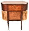 Sheraton Cherry Sewing Stand
having lift top and ovolo ends with pleated bag
sides flanked by large center drawer having birds eye maple front
set on 