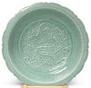 A LARGE CHINESE CELADON BOWL, decorated in low relief with a dragon. 54cm d