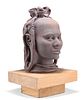AN AFRICAN TERRACOTTA SCULPTURE OF A FEMALE HEAD, mounted on a wooden board