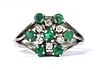 A silver emerald and diamond cluster ring,