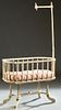 French Louis XVI Style Polychromed Beech Baby Crib, early 20th c., the cartouche shaped crib with a turned reeded mosquito netting hook on one end, on
