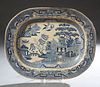 English Ironstone Blue Willow Platter, 19th c., of oval form, with blue landscape decoration, unmarked, H.- 1 1/2 in., W.- 18 1/8 in., D.- 14 1/2 in.