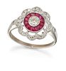 A RUBY AND DIAMOND CLUSTER RING, a round brilliant-cut diamond within a mil