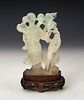 Figure of fairy with bird. China, 20th century. 
Jade carved by hand on wooden base.