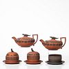 Five Wedgwood Egyptian Items, England, early 19th century, four in rosso antico with applied black basalt relief: two covered teapots with crocodile f