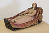 A polychrome painted wooden figure of a reclining female,